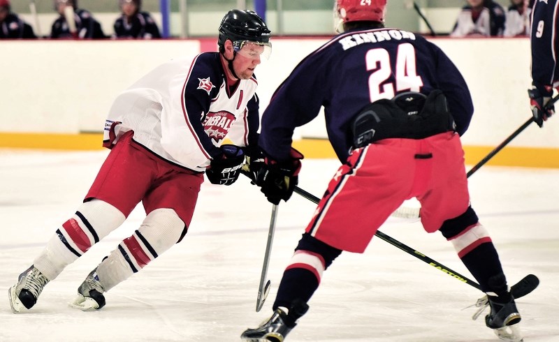 Tanner Boothby (left) races the puck into the zone as the Alumni team went on to beat the Cochrane Generals current roster 16-3 on Dec. 19 at Spray Lake Sawmills Family