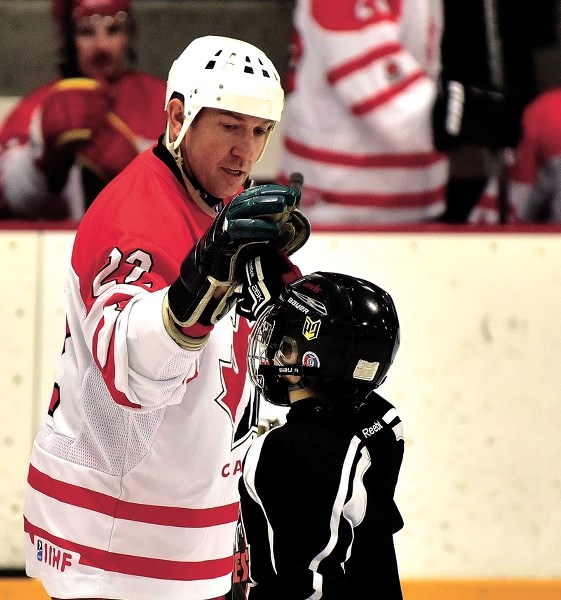 Sheldon Kennedy celebrates a goal as St. Timothy School students were treated to a bit of a spectacle with former NHL stars Sheldon Kennedy, Curtis Glencross and Colin Forbes 