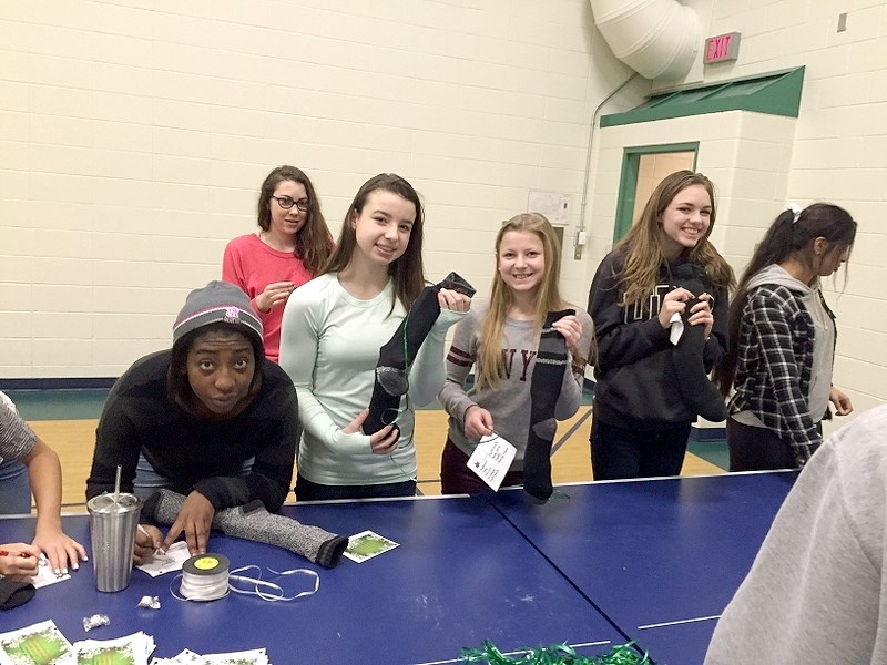Springbank Community High School students display socks stuffed with donated essential items bound for the Mustard Seed in Calgary, which delivers basic services, housing and 
