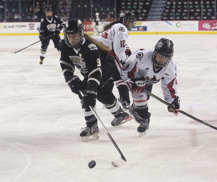Cochranite and Rockyview Raiders forward Nicolette Seper (#3) wins the dash to the puck before Northern Capitals&#8217; Caily Mellott (#9) in the Mac&#8217;s Midget
