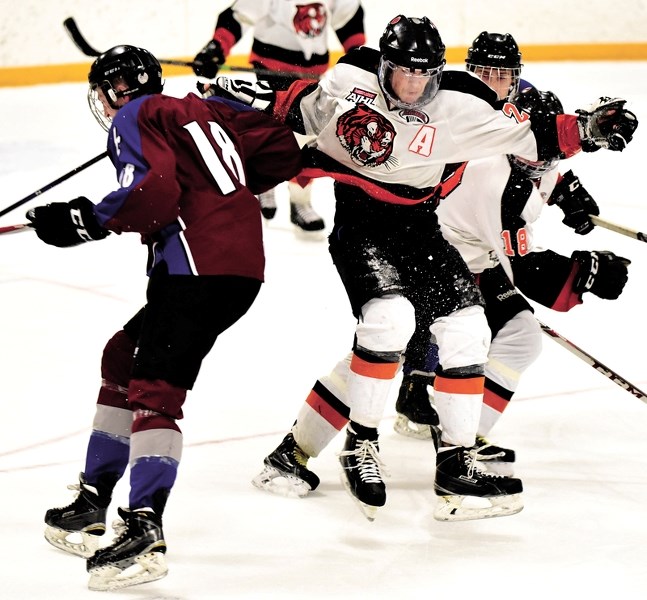 Luke Jensen (left) of the AC Avalanche drills a Medicine Hat Tigers forward with a booming hit on Jan. 9. The Tigers weathered the Avalanche and left Cochrane with a 6-4 win.