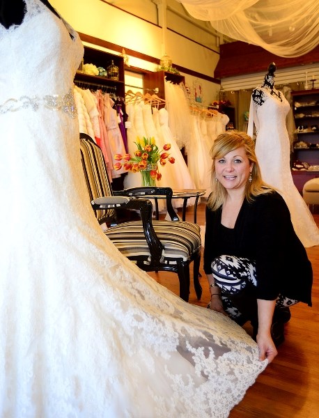 Cyndi Campone of the Bridal Experience Boutique bridal shop in Cochrane adjusts the placement of a wedding dress.