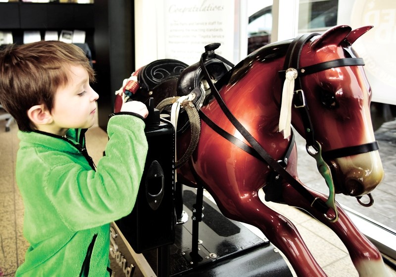 James Fay, 4, tests out the newest old attraction in town at Cochrane Toyota on Jan. 21. A 1956 ride-on horse, which was a staple at most grocery stores back in the day, has