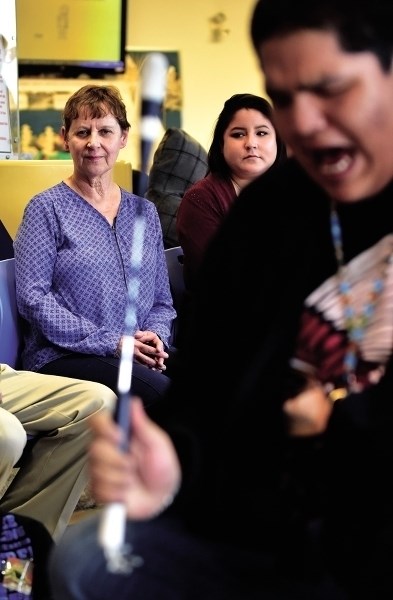 Dr. Heidi Schroter and daughter Beth watch and listen to the drum circle as Cedric Lightning belts out notes with the Spirit Mountain Dance Troop. After 25 years Dr. Heidi