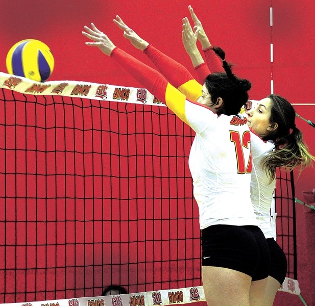 Cochranite and University of Calgary women&#8217;s volleyball player Beth Vinnell (left) and her teammate Jillian Lazic (right) successfully block the ball during the second