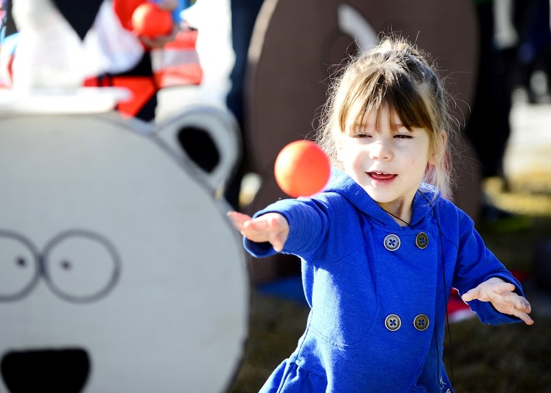 Abbey Lane, 3, hurls a ball to try and knock off a pin from the head of a cut-out bear at last year&#8217;s Winterfest event. Hundreds flocked to Cochrane&#8217;s WinterFest