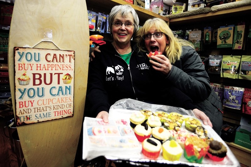 Jo Ann Whiteside (left) and Global Pet Foods owner Fiona Sharman show off some delicious treats for sale in support of the Cochrane &#038; Area Humane Society&#8217;s cupcake 