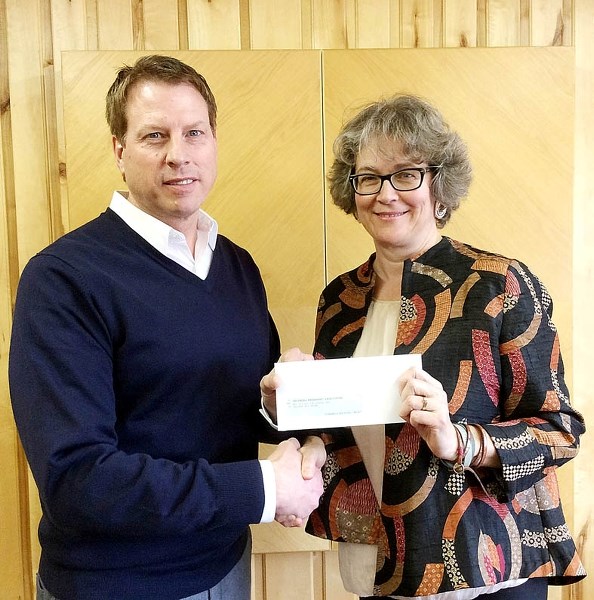 Pat Findlater, chief financial officer from Spray Lake Sawmills, presents Laurel Pedersen, executive director of the Cochrane Pregnancy Care Centre, with a cheque Feb. 10.