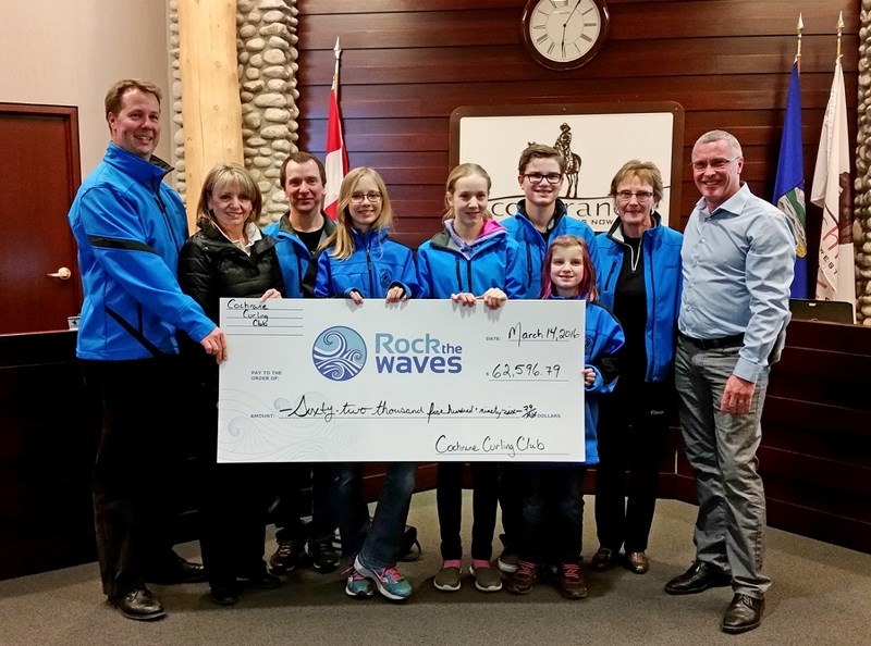 Mayor Ivan Brooker accepts a cheque from the Cochrane Curling Club to the Rock the Waves campaign for $62,596.79 at the March 14 council meeting at the RancheHouse.