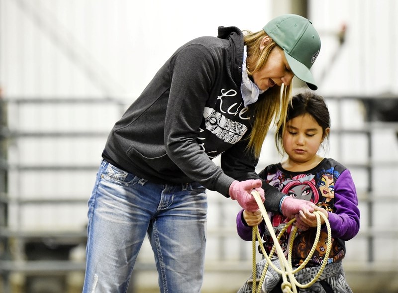 Equine instructor Megan Lunak (left) shows Summer Holloway the ropes (literally), on March 17 at the Bearspaw rodeo grounds. They are taking part in the Bearspaw