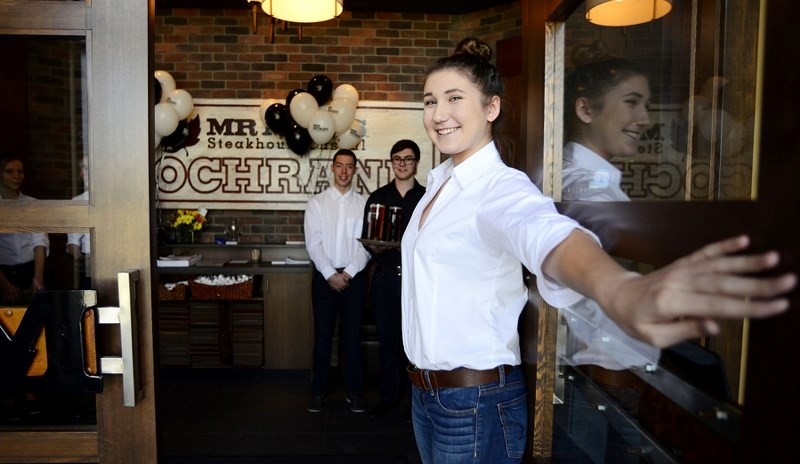 Hostess Jennifer Diuga welcomes folks into a private function to help raise money for the Rock the Waves campaign at the newly opened MR MIKES restaurant in Cochrane on March 