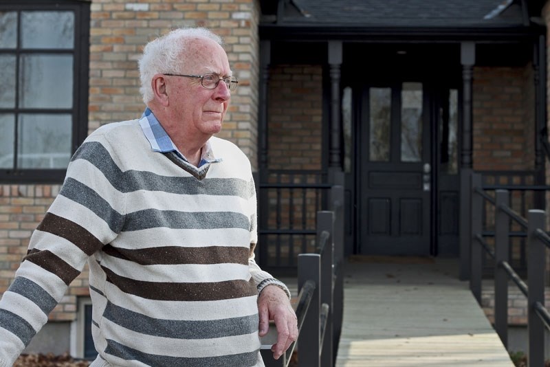 Gordon Davies reflects in front of the house he grew up in. Originally built by his grandfather in 1909, the house was used as Cochrane&#8217;s first hospital. The house now