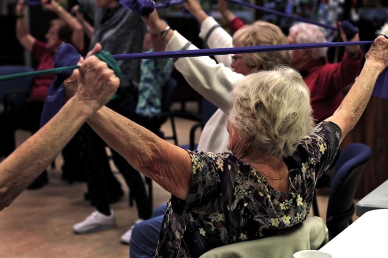 A participant of Seniors on the Bow Centre&#8217;s chair exerise class demonstrates her resistance training during the workout. The class is just one of the many programs