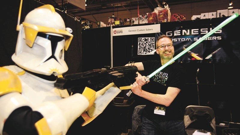 Cochrane&#8217;s own illuminated saber creator Rob Petkau (back), faces off against Ben Yep at the Genesis Illuminated Sabers booth at the Calgary Comic and Entertainment