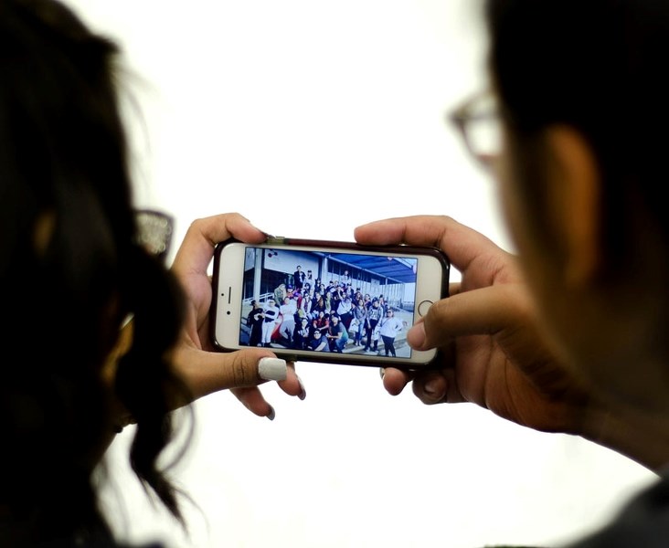 Morley Community students Serenity Obey, 14, and Alieka Kaquitts, 16, sit down and go through the photos of the YMCA youth exchange, where 15 Stoney youth got to visit