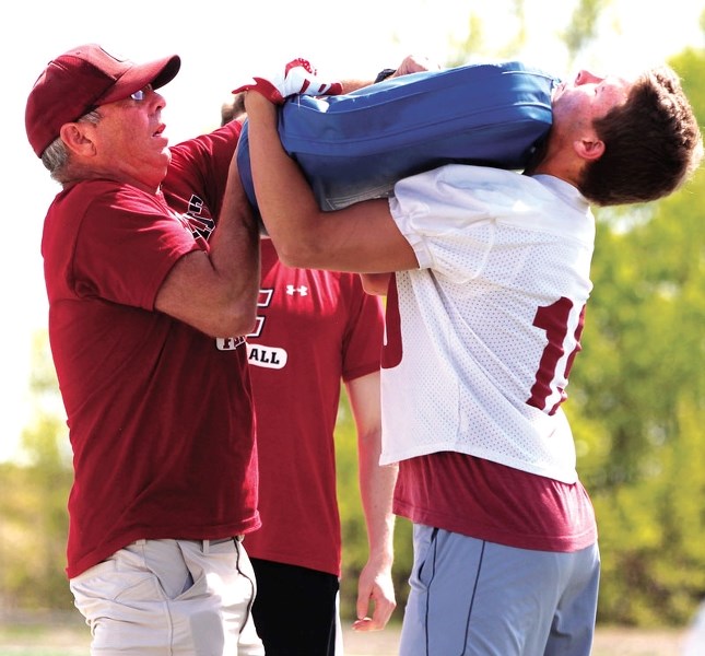 Cobras co-head coach Bruce O&#8217;Neill (left) and Jackson McLean (right) demonstrate a hitting drill during the Cobras&#8217; training session at Spray Lake Sawmills Legacy 
