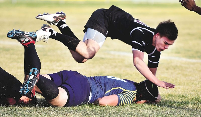 Craig de la Mare (in blue) gets tackled as the Cochrane Bears took to the field against the Foothills Composite Falcons on April 27. The Bears ended up losing the game 33-12. 