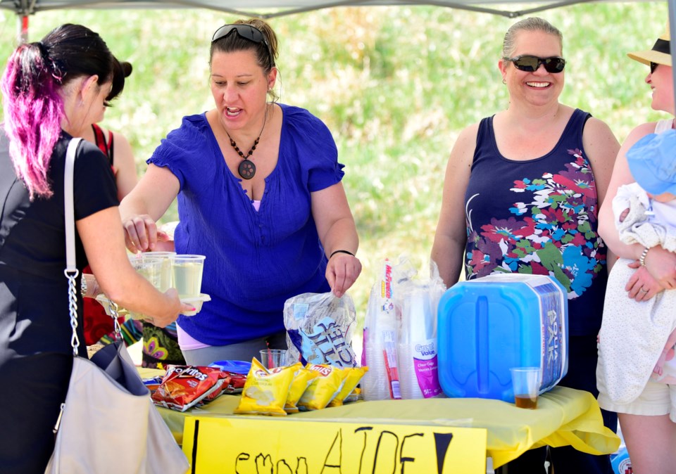 Left, Jakki MacKenzie stirs up some lemonade with her friends Mel Southam and Crystal Bohn as they helped out with the LemonAide fundraiser on May 7 at Mitford Park. Funds