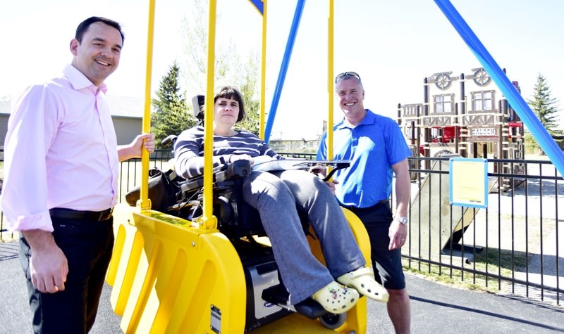 MP Blake Richards, and Cochrane Mayor Ivan Brooker push Katie Kelly on the new Liberty Swing in West McDougall on May 6