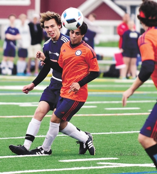 Bow Valley High School Bobcat Max Perron (in blue) tries to win the ball during his team&#8217;s 11-1 victory over WH Croxford on May 5 at Spray Lake Sawmills Legacy Field.