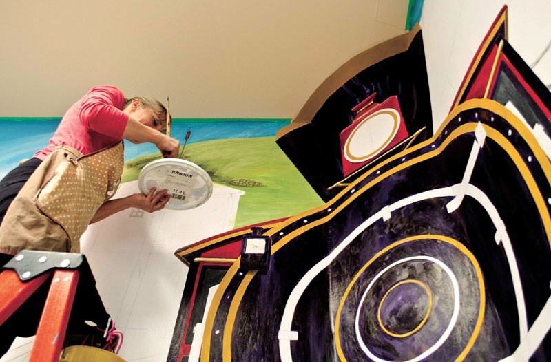 Artist Louise Robinson working on the Cochrane mural at the Nan Boothby Memorial Library.