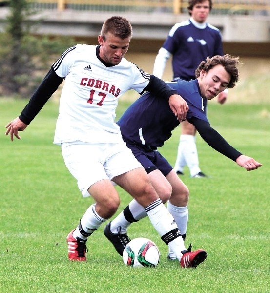 CLASH OF TITANS: Cochrane High School Cobras boys soccer player Dominik Zuczek (white) and Bow Valley Bobcat Ewan Rodgers battle it out for the ball during the May 19 clash