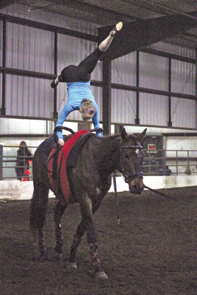Brooke Boyd, with Diamond Willow Vaulting Club, demonstrates her strength and flexibility during her vaulting performance at the Raise the Barn fundraiser. The club was one