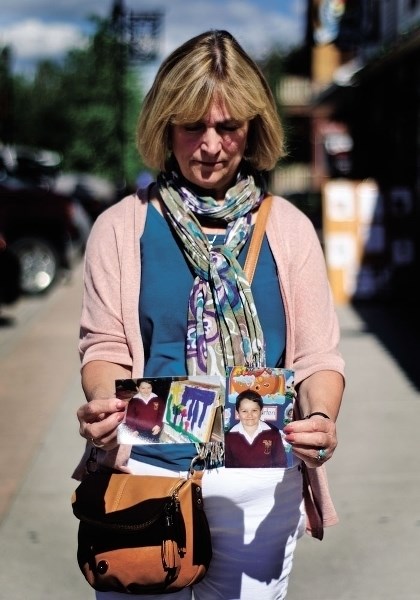 Sandy Wong holds photos of Alex Radita. Wong is fighting for better child welfare protection.