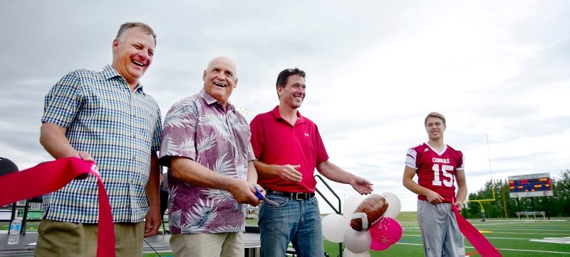 Left to right: Cam Cote, Dean Lang, and Paul McLean cut the ribbon on the new turf field. Legacy Field finally had its grand opening on June 18 as members of the community