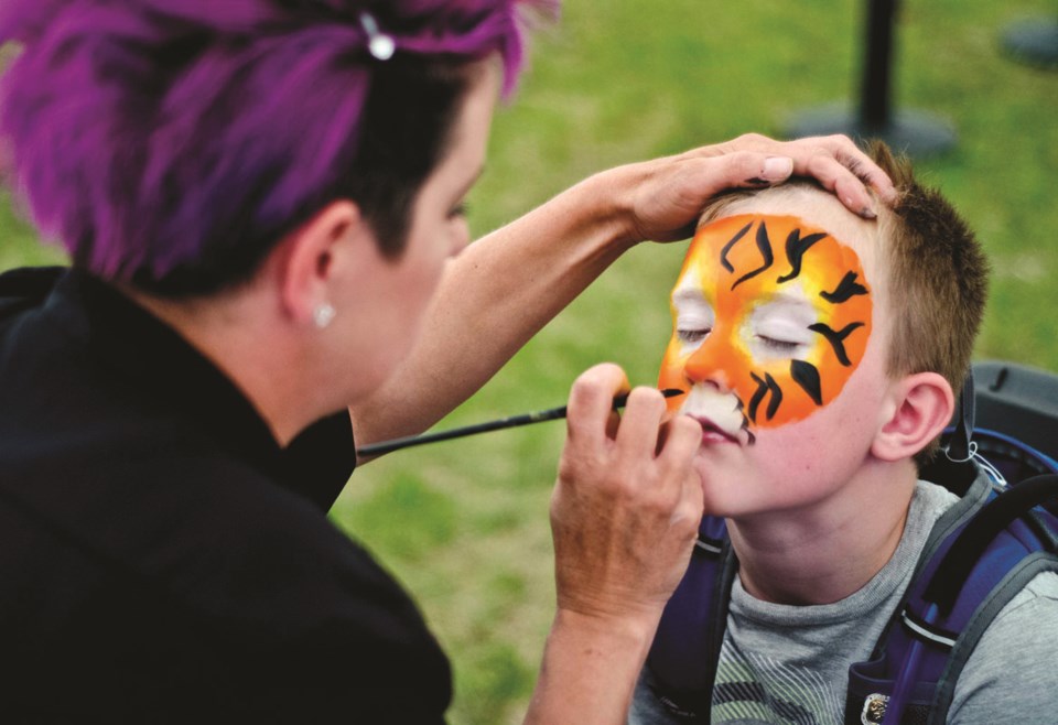 Face and body painter Anthea McIntyre spent last Sunday turning children, such Reid Boukall (right) into lions, tigers and fairies at the inaugural Cochrane Summer Light Up