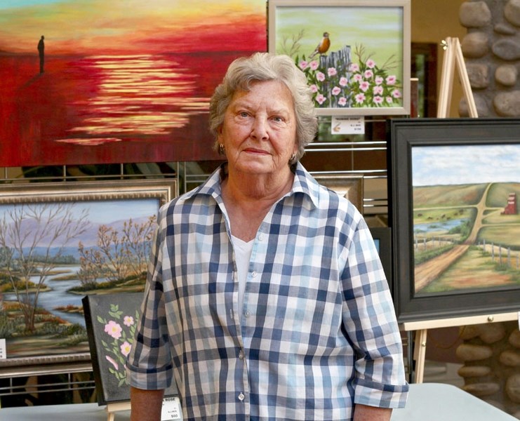Beryl J Moe poses with some of her art.
