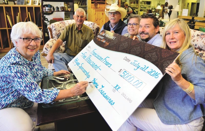 From left, Barb Primeau, board chair of Home Treasures, writes a cheque for $5,000 to present to the members of the Cochrane Syrian Refugee Sponsorship Group, Andy Marshall,