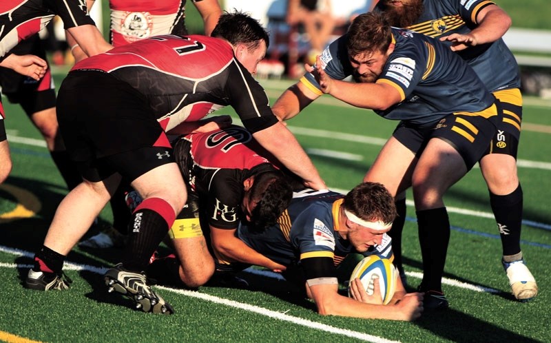 Bow Valley Grizzlies Connor Gilbert (on ground) and Cody Snoxell try to maintain ball possession and ruck during their side&#8217;s 61-0 victory over the Calgary Saints on