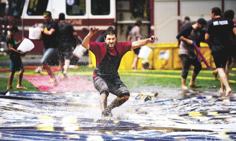 Danny Court slides across the massive slip and slide mat. Campers, counsellors and firefighters were all smiles at Camp Horizon for their annual Alberta Fire Fighter Burn