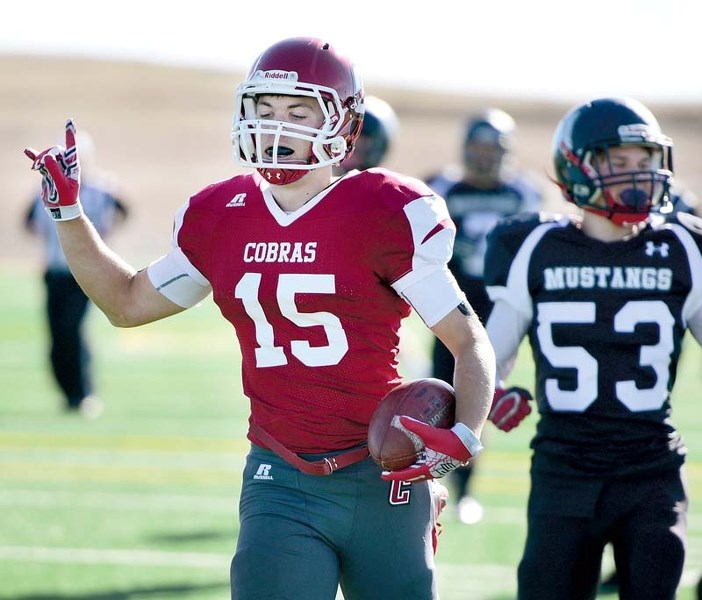 Giving the rock and roll devil horns, Cobras left back Jackson McLean rushes in a touchdown against the George McDougall Mustangs on October 22.