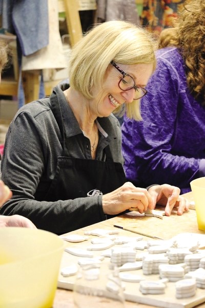 Potter Brenda Spicer paints dozens of charity Christmas ornaments at Saffron Collective Studio on Nov. 12.