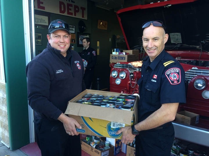 Cochrane firefighter Adam Robbie (left) and Captain Martin Reuter (right) loading up food donations for the Veterans Food Bank.