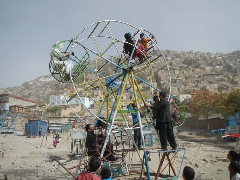 Families enjoying the Ferris wheel in a playground in Kabul, Afghanistan.