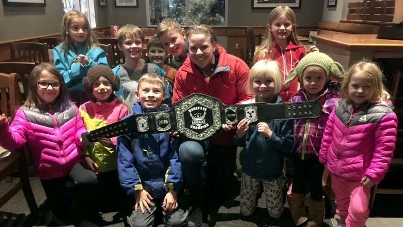 Helen Schott (centre) poses with her Battle in the Barracks belt, which she won on Dec. 4.