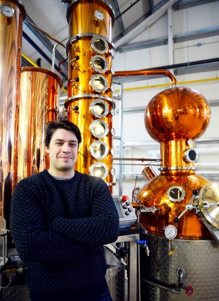 Distiller Travis Green stands in front of the distilling equipment at Krang Spirits, which opened its doors this past weekend.