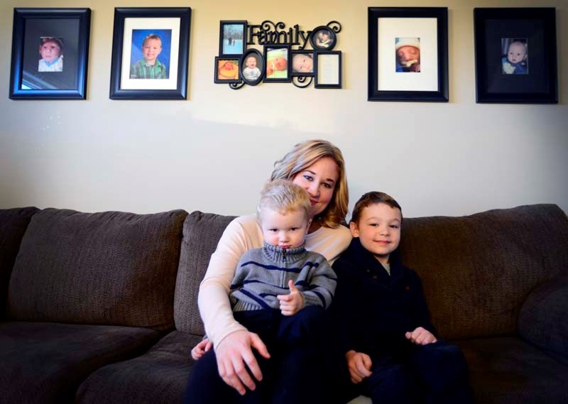 Jennifer Snelgrove, a mother of four, sits with two of her children, three-year-old Brennan and seven-year-old Joshua. Snelgrove is supportive of Banff-Airdrie Conservative