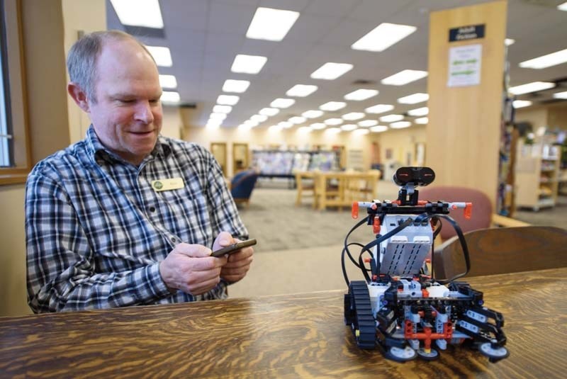 Public service assistant Kyle Novak gets behind the controls of Lego robot Ev3storm, also known as &#8220;Ev3&#8221;, at the Nan Boothby Library