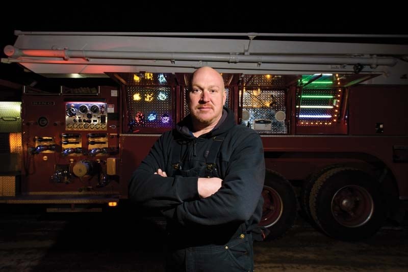 Andy Hill poses with his lit up fire truck.