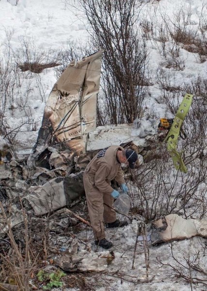 A Transport Safety Board of Canada investigater combs over the site of plane crash near Cochrane.