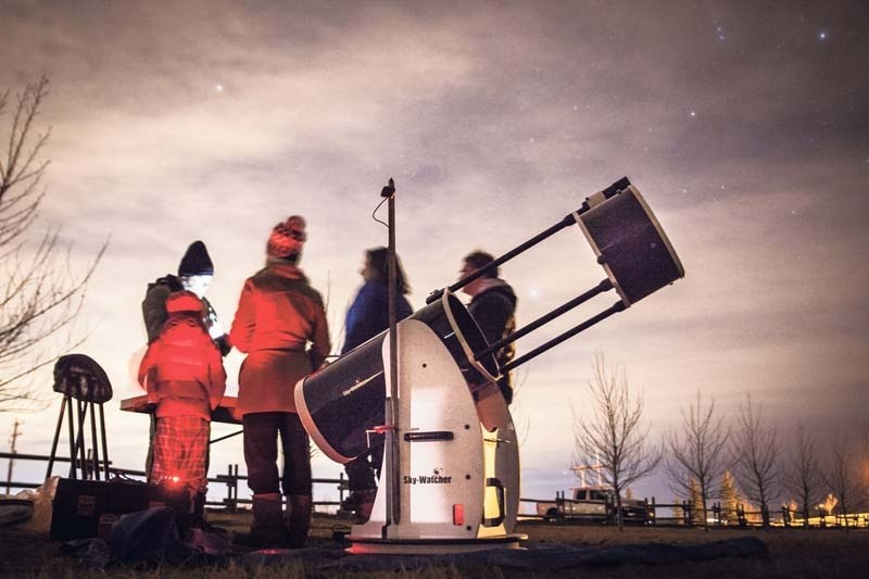 A group of onlookers learn about the universe from Cochrane amateur astronomer Tim Giese at a stargazing event Feb. 17 in Mitford Park, organized by the Nan Boothby Memorial