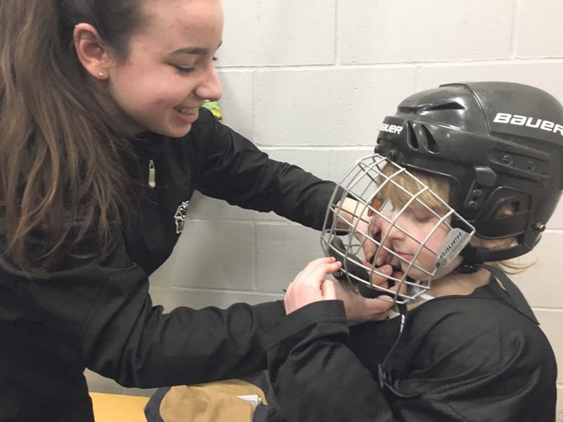 Stephanie Gross adjusts Lucy Johnson&#8217;s helmet at Girls Try Hockey Day Feb. 19