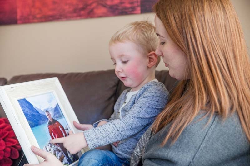 Two-and-a-half-year-old Austin sits in mother Emilie&#8217;s lap and points to a photo of his father, Shaun, who died in a car wreck Feb. 15.