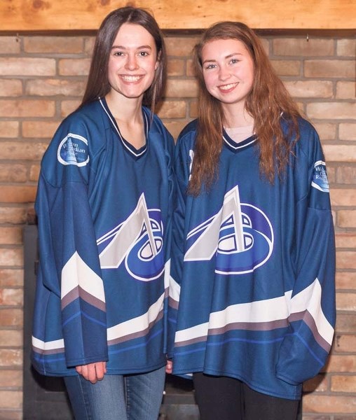 U19A ringette players Danielle Rosenberg and Rovanna Irvin show off their Team Alberta jerseys.