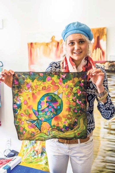 Artist Cydney Galbraith holds up a silk scarf creation.