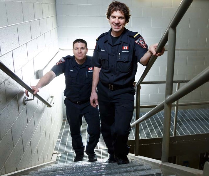 Two firemen, Chris Chyka, left, and Derek Orr, pose for a portrait on the stairs they train on for the annual Firefighter Stairclimb Challenge at the Cochrane Firehall in